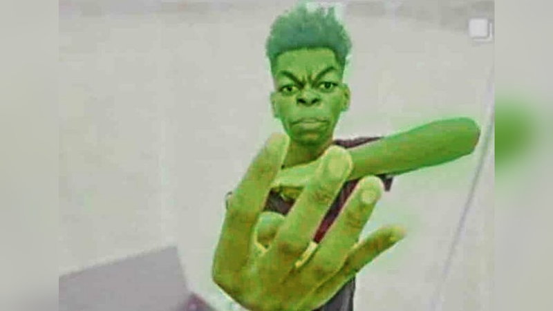 Beast Boy / Green Guy Holding Up Four Fingers meme depicting an edited photo of a Black man with an exaggerated scowl and green skin looking into the camera.